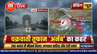 People holding umbrellas during heavy rain in Delhi NCR due to cyclone Arnab